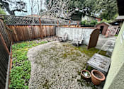 Thumbnail 38 of 38 - A backyard with a wooden fence and a small patio area.