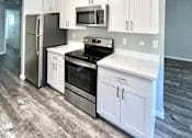 Thumbnail 1 of 16 - a small kitchen with white cabinets and stainless steel appliances