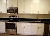 Thumbnail 1 of 22 - a kitchen with a stove microwave and white cabinets