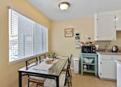Thumbnail 25 of 36 - A kitchen with a table and chairs by a window.