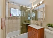 Thumbnail 13 of 36 - A bathroom with a white sink and a glass shower door.