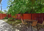 Thumbnail 15 of 36 - A table and chairs are set up in a backyard.