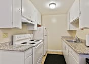 Thumbnail 27 of 36 - A kitchen with white appliances and cabinets.