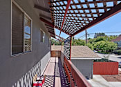 Thumbnail 14 of 36 - A patio with a red pergola and a black and white checkered floor.