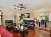Thumbnail 21 of 36 - A living room with a red couch and a ceiling fan.