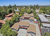 Thumbnail 26 of 36 - A large building with a red roof is surrounded by trees.