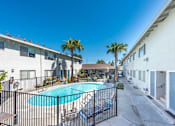 Thumbnail 9 of 32 - a swimming pool is between two buildings with palm trees