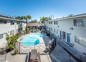 Thumbnail 1 of 32 - a pool is surrounded by two buildings and a courtyard