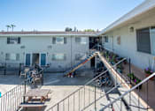Thumbnail 3 of 32 - an apartment building with stairs and a patio with bikes and a picnic table