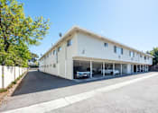 Thumbnail 13 of 32 - a large white building with cars parked outside of it