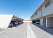 Thumbnail 18 of 32 - an empty parking lot between two buildings with cars parked