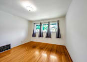 Thumbnail 11 of 25 - an empty room with three windows and a wood floor