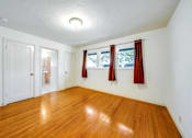 Thumbnail 5 of 25 - a living room with a hard wood floor and a window with red curtains