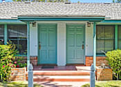 Thumbnail 6 of 25 - a blue house with two doors and a porch