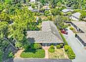 Thumbnail 2 of 25 - an aerial view of a building surrounded by trees and a parking lot