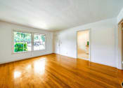 Thumbnail 8 of 25 - an empty living room with wood floors and a window