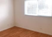 Thumbnail 6 of 15 - an empty room with a window and wooden floors