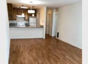 Thumbnail 11 of 15 - an empty living room and kitchen with wood flooring
