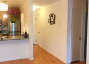 Thumbnail 9 of 15 - an empty living room and kitchen with a wood floor