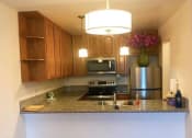 Thumbnail 8 of 15 - a kitchen with stainless steel appliances and a granite counter top