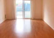 Thumbnail 7 of 15 - an empty living room with wood floors and a balcony