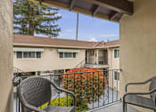 Thumbnail 8 of 43 - a patio with two chairs and a balcony overlooking a building