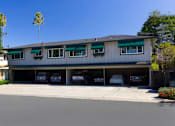 Thumbnail 12 of 13 - A building with a green roof and a garage with several cars.