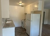 Thumbnail 9 of 13 - A kitchen with a sink, stove, and refrigerator.