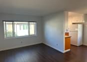 Thumbnail 4 of 13 - A room with a window and a refrigerator.