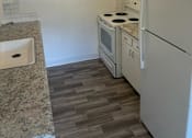 Thumbnail 11 of 13 - A kitchen with a white refrigerator and a white sink.