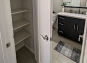 Thumbnail 9 of 11 - a walk in closet in a bathroom with a sink and a toilet