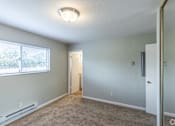 Thumbnail 20 of 30 - an empty room with a large window and a door to a hallway