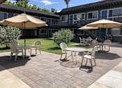 Thumbnail 19 of 30 - a patio with tables and umbrellas in front of a building