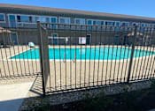Thumbnail 29 of 30 - a swimming pool with a fence in front of it