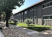 Thumbnail 1 of 30 - a black building with a sidewalk and grass in front of it