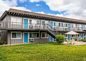 Thumbnail 5 of 30 - a large gray house with blue doors and a grass yard