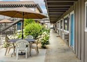 Thumbnail 2 of 30 - a patio with a table and chairs under an umbrella