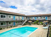 Thumbnail 11 of 30 - a swimming pool in front of a hotel with a pool