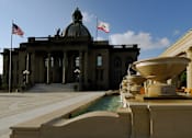 Thumbnail 22 of 27 - a fountain in front of a building with two flags