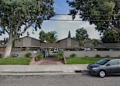 Thumbnail 13 of 17 - A street view of a residential area with cars parked on the side of the road.