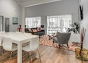 Thumbnail 4 of 15 - A white dining table with four chairs is in the center of a room with a wooden floor.