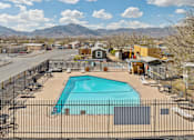 Thumbnail 3 of 4 - A pool surrounded by a fence with mountains in the background.