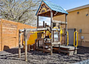 Thumbnail 4 of 4 - A wooden playground structure with a blue roof and yellow slides.