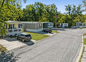 Thumbnail 4 of 15 - A car is parked on the side of a road in front of a house.