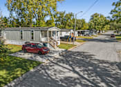 Thumbnail 3 of 15 - A red car is parked in front of a house.