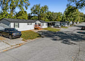 Thumbnail 5 of 15 - A black truck is parked on the side of a road in front of a house.
