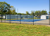 Thumbnail 11 of 15 - A black fence surrounds a blue pool.