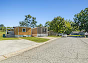 Thumbnail 6 of 15 - A street view of a residential area with houses and a car parked on the side.