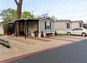 Thumbnail 1 of 8 - A white car is parked on the street in front of a house.