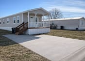 Thumbnail 5 of 6 - A mobile home with a porch and a covered patio.